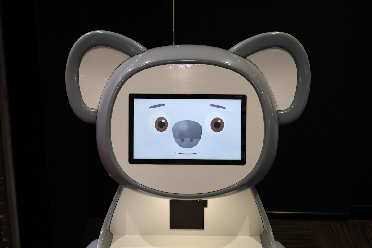 Close-up of the koala Junior's touchscreen face and integrated receipt printer at Adilam's conference stand.